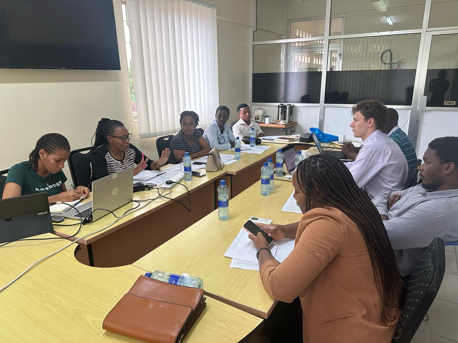 Researchers discussing a project around a conference table at the Economic and Social Research Foundation